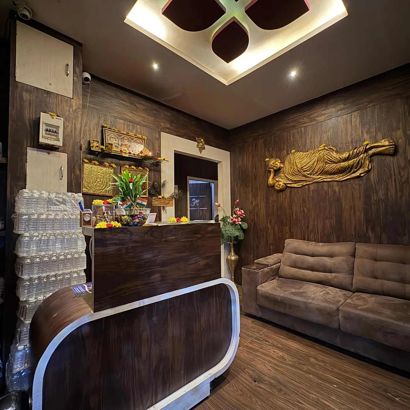 Reception at Ocean Leaf Premium Spa with dark wood panelling and a golden reclining Buddha wall sculpture